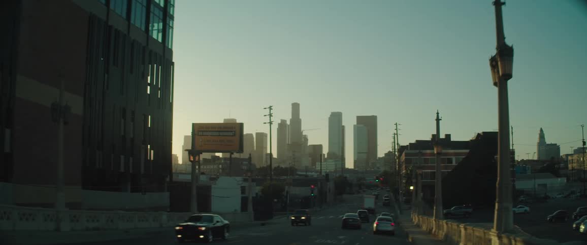 Cars drive on a busy road in a city