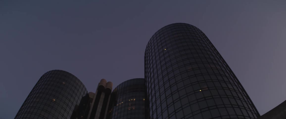 Exterior of round office building tower at night