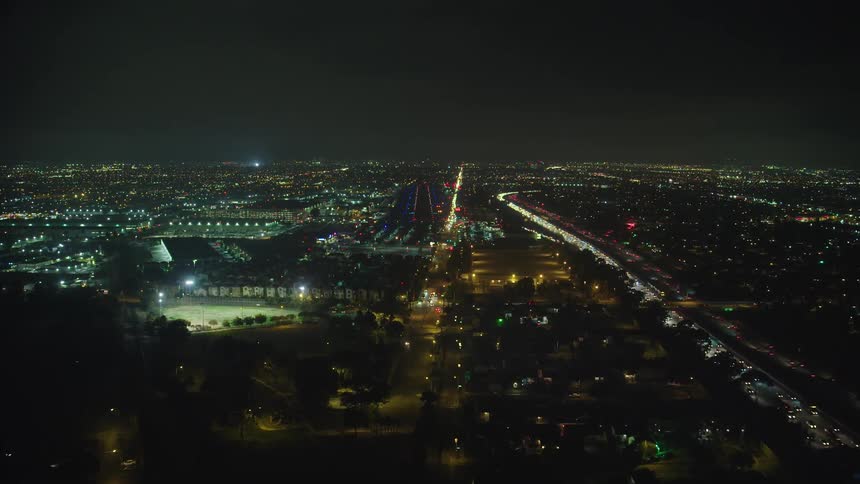 Aerial view of the illuminated city and traffic jam on the highway