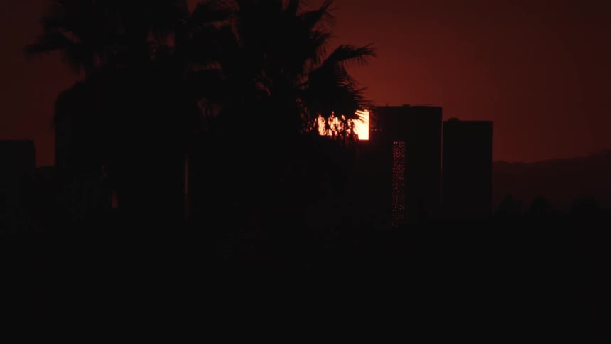 City skyline with sun setting on red sky