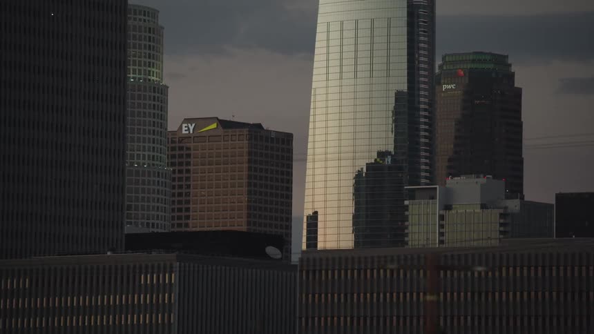 The city is full of tall buildings at sunset