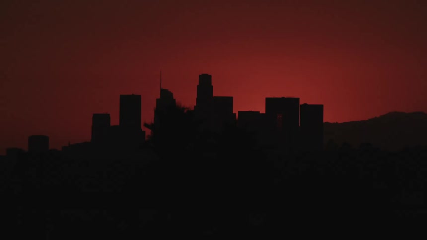 City skyline silhouetted against dark red sky