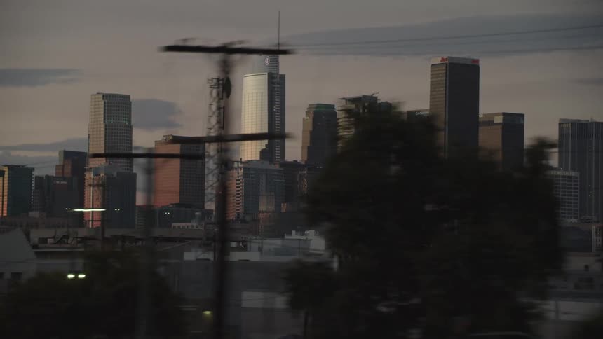 City downtown at sunset filmed from a train
