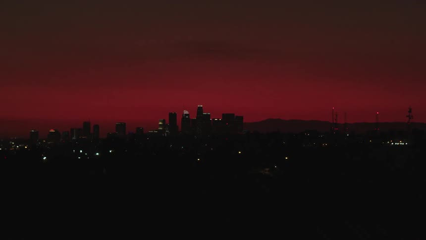 A city skyline with trees in the foreground and the sky in the background