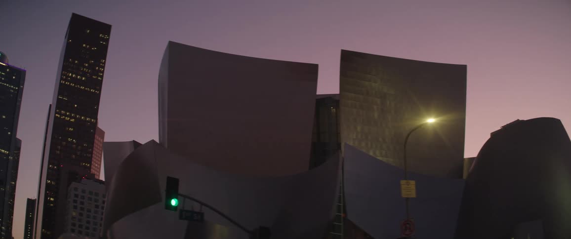 An elaborately structured building in a metropolis at dusk