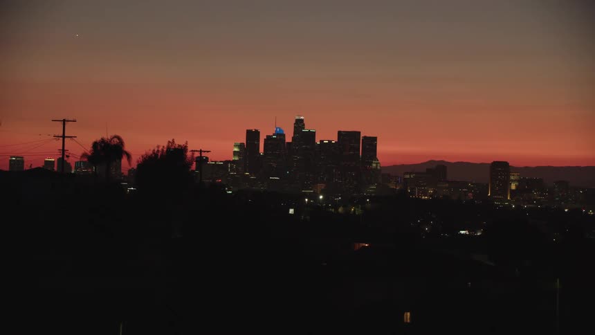 City silhouetted against red sky at sunset