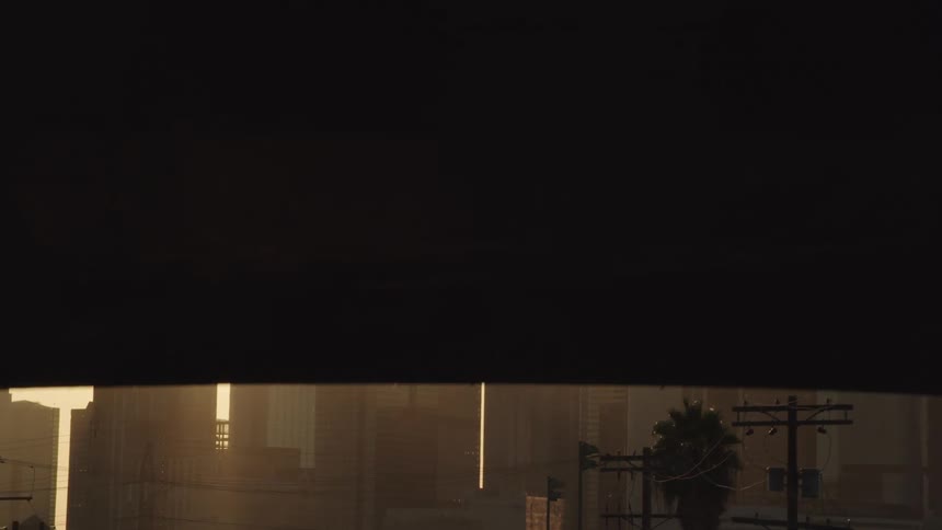 An overpass with vehicles driving by with the city skyline in the background