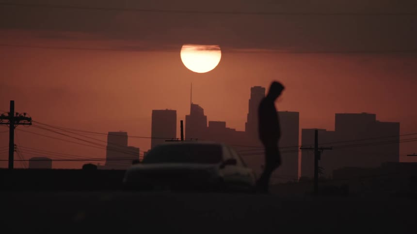 A man crosses the street as cars drive by