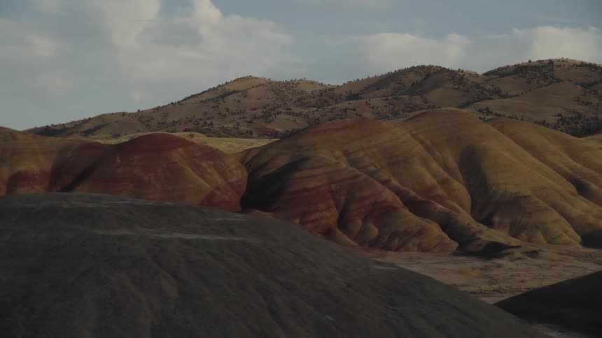 Mountains with yellow and red striations under a cloudy sky