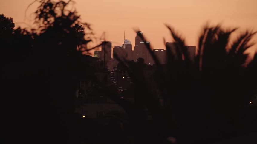 The sun is setting in the horizon above the skyline
