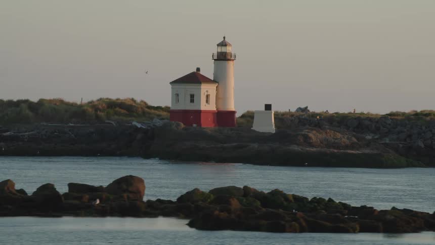 A light house sits next to the ocean