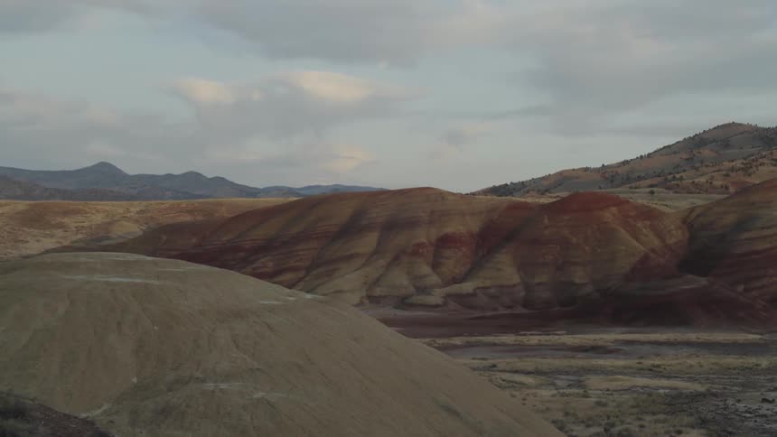 A valley with little vegetation between two ridges of hills in the badlands