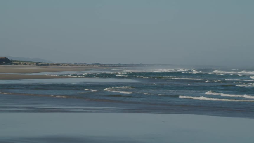 Ocean waves break against the shore during the daylight