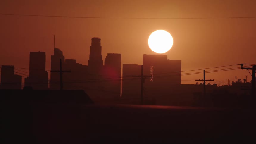 The sun sets over the city skyline