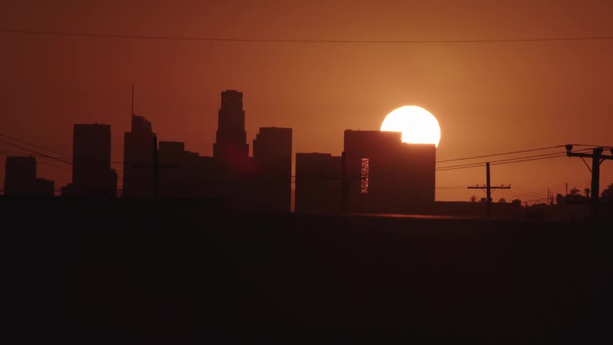 The sun peaks over skyscrapers
