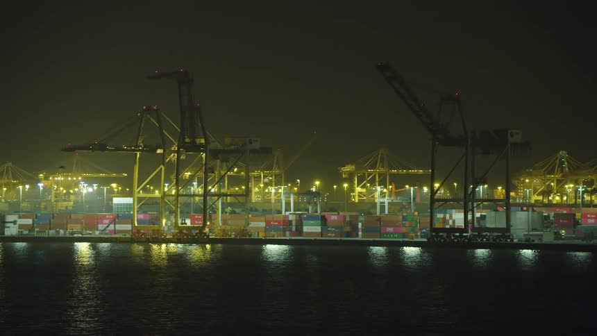 A shipping yard illuminated with bright lights at night