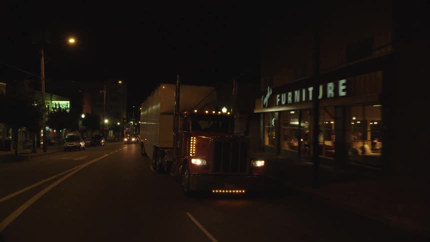 A truck drives on the road at night