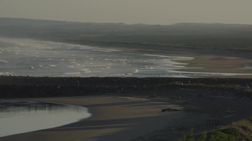 A beach at low tide with waves and sand