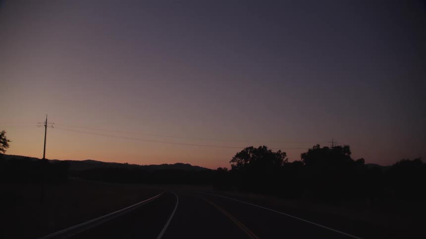 The cars drive at sunset on the highway