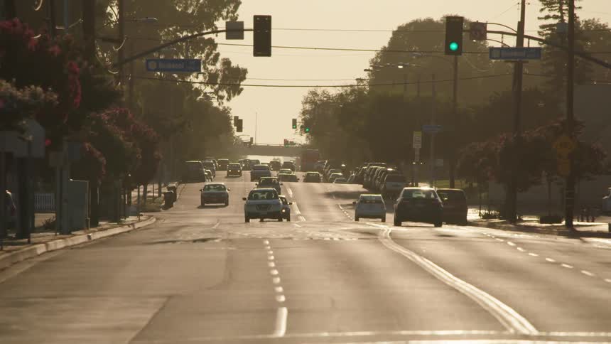 Cars drive on a highway through a small town