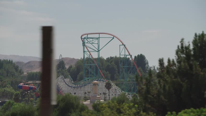 A roller coaster with trees and mountains in the background