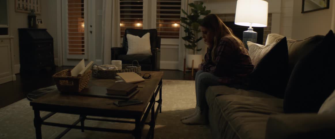 Woman feeling bored sits on the couch in the living room