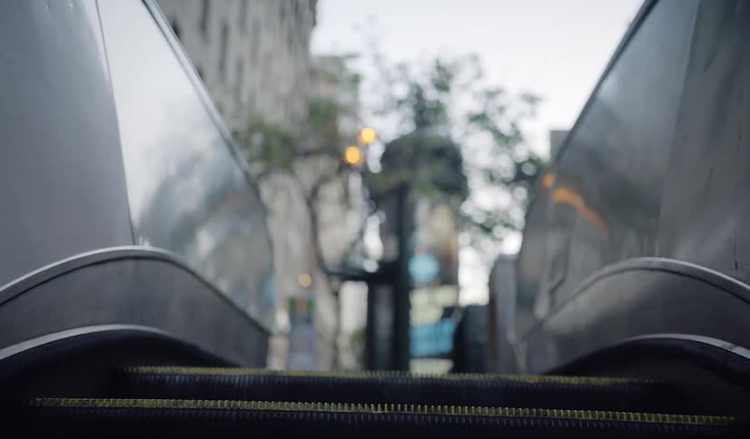 Escalator out of subway station to city streets at day