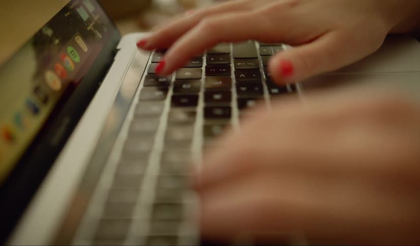 Woman sitting at the desk uses a laptop
