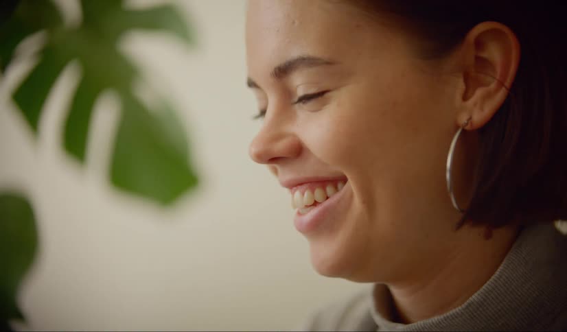 Woman sitting at the desk makes a video call in the living room at home