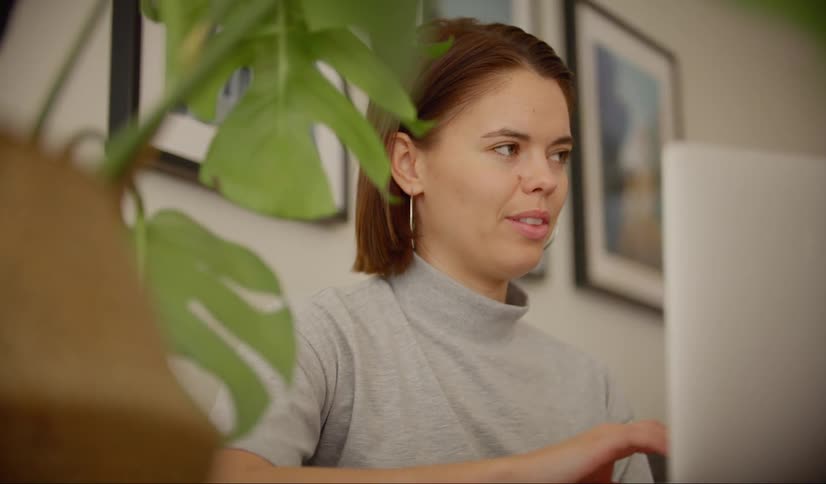 A young woman video chats with someone on her computer