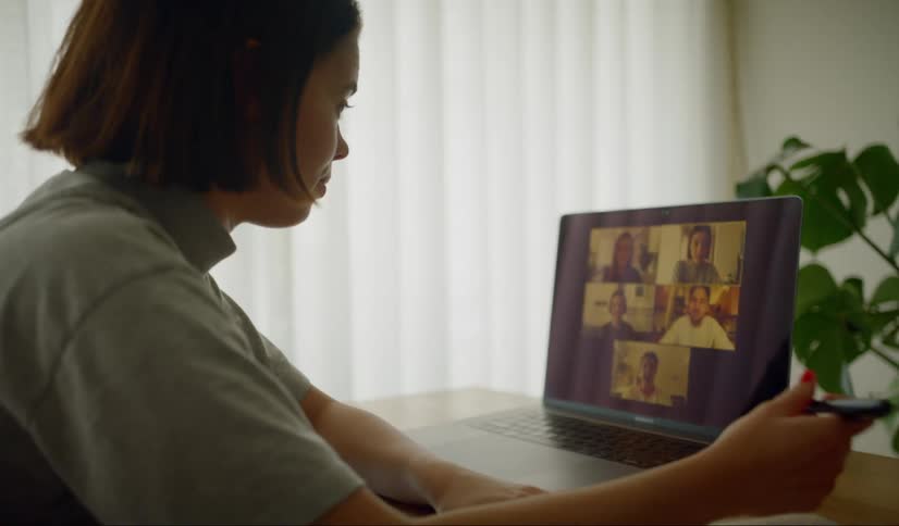 A woman talks to others on video
