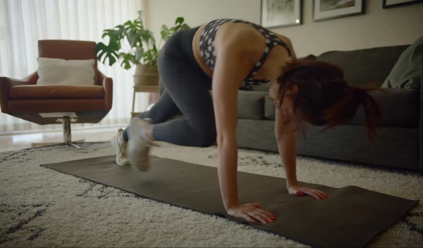 A woman is down on all fours stepping in an exercise motion