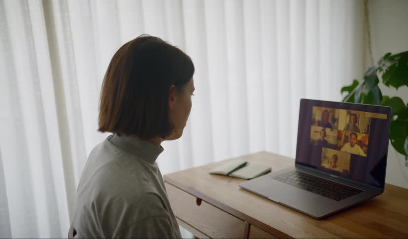 Woman on video conference with colleagues while working remotely