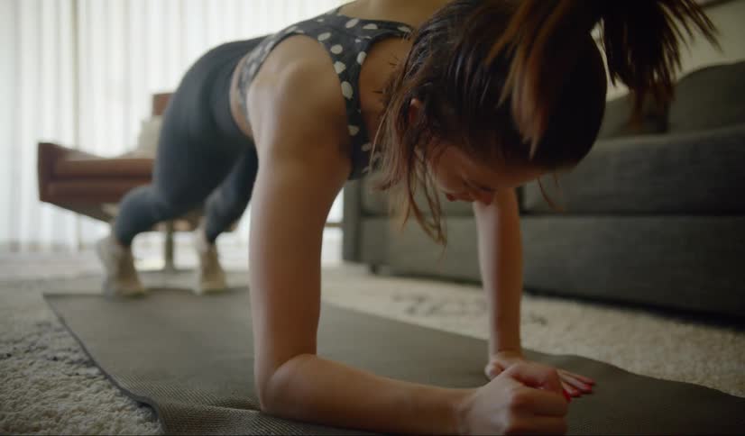 A teenager exercises on a mat at home