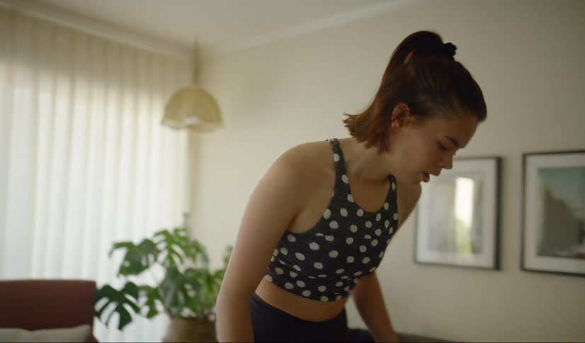 A female jumping and kneeling in a flat