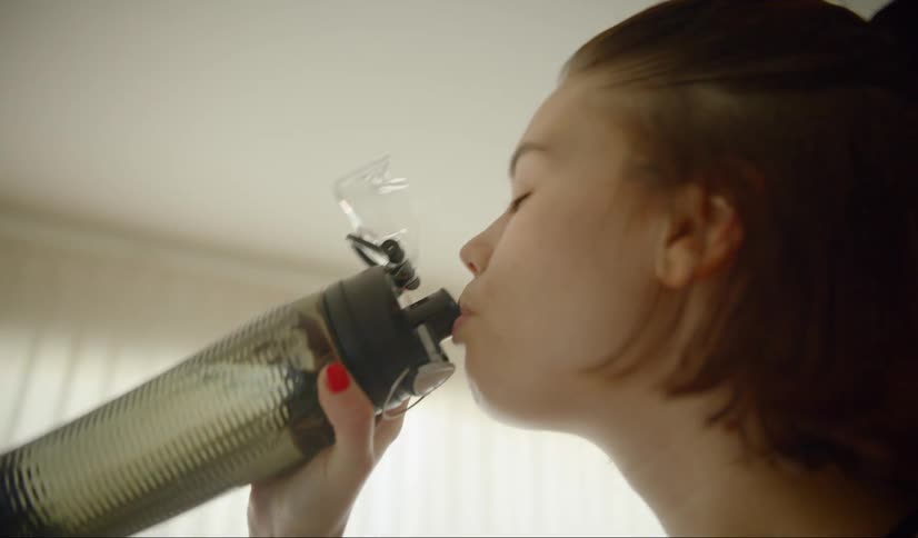 A teenager drinks out of her water bottle