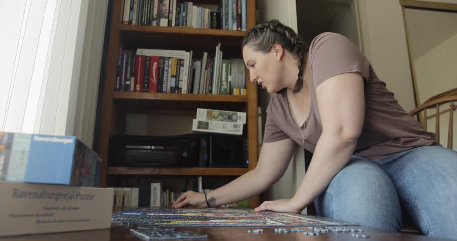 A female is working on a puzzle