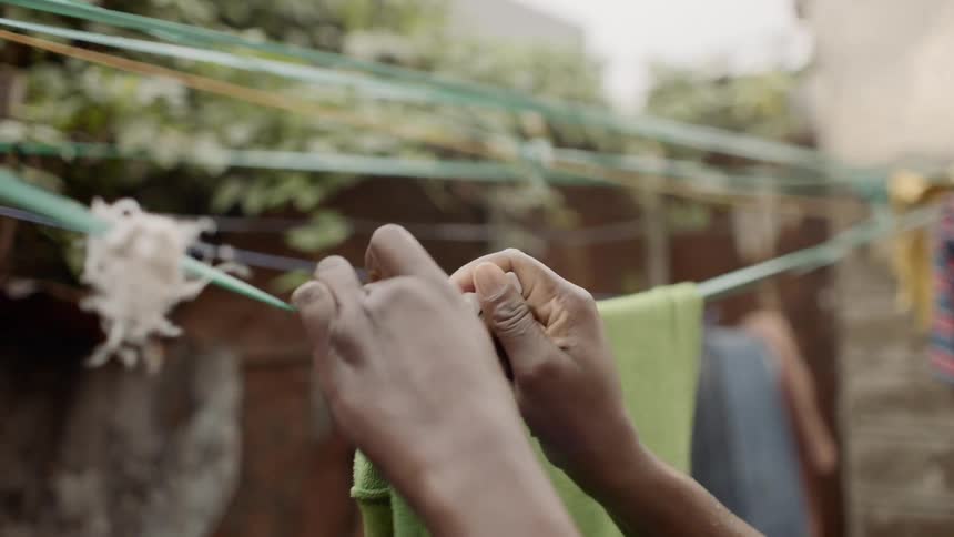 Close up of laundry being hung on a clothesline outdoors