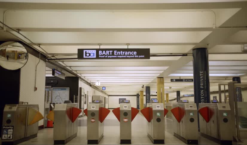 A train station with turnstiles and signs