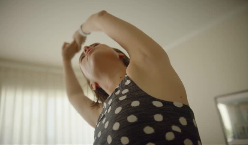 A woman stretches in her living room