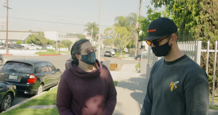 Couple wearing face masks walk around the neigborhood