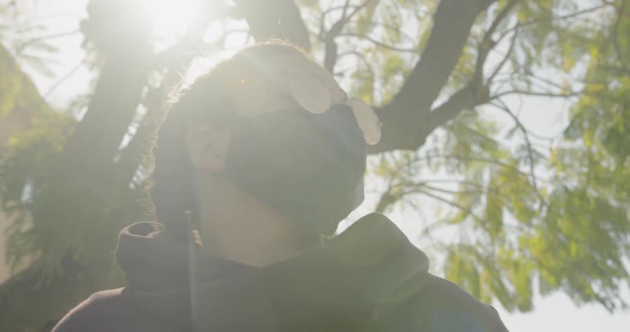 A woman wears a mask and sunglasses