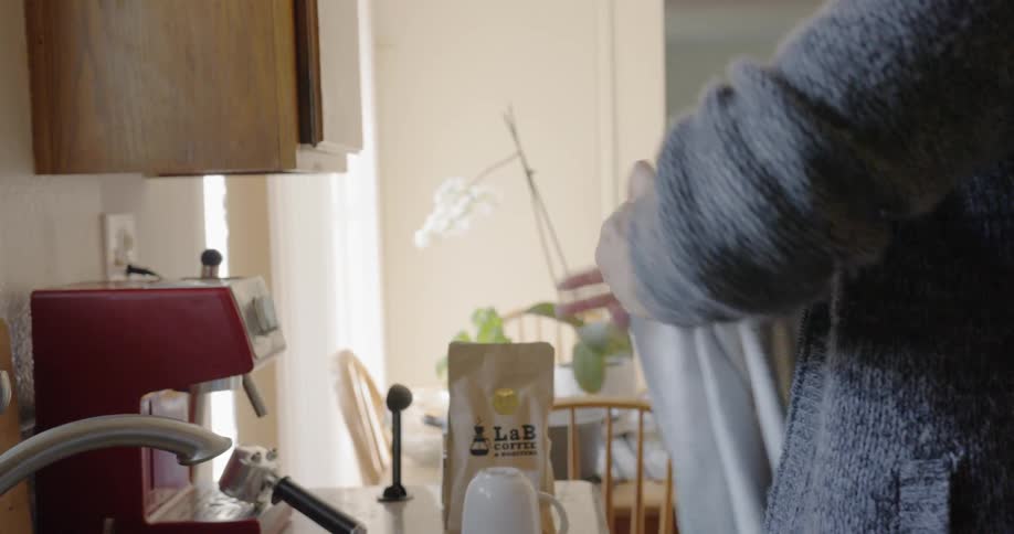 Man drives a cup with a white towel in the kitchen