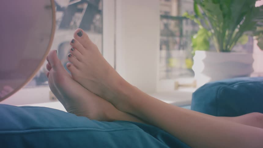 A womans feet resting on a couch