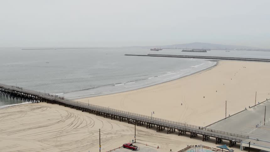 A large bridge goes out to the ocean water