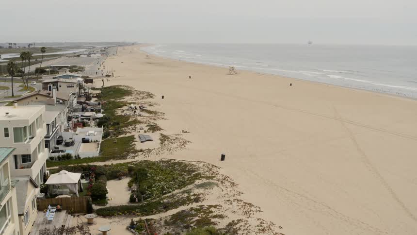 Beach houses near the coast with sand and trees