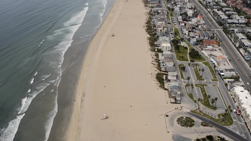 An empty beach with cars and streets off of it