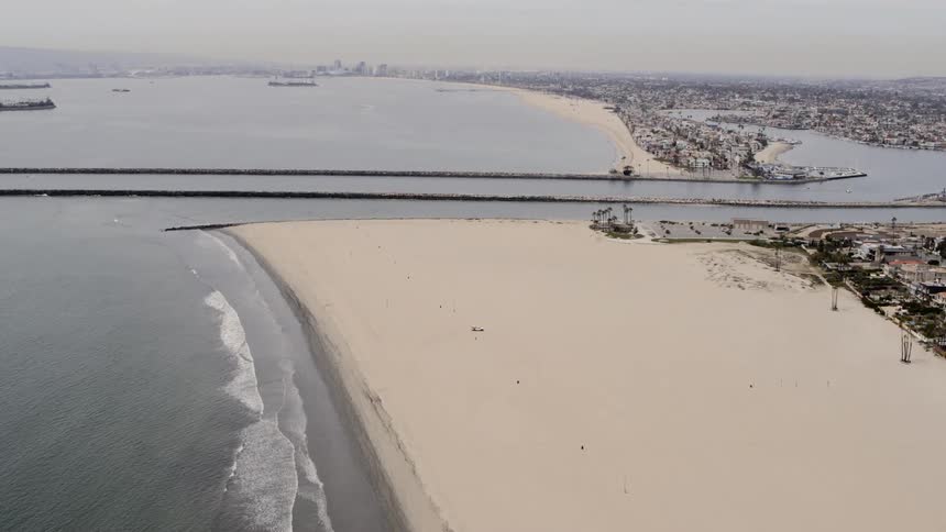 Large town with skyline on distant horizon borders beach channel and ocean