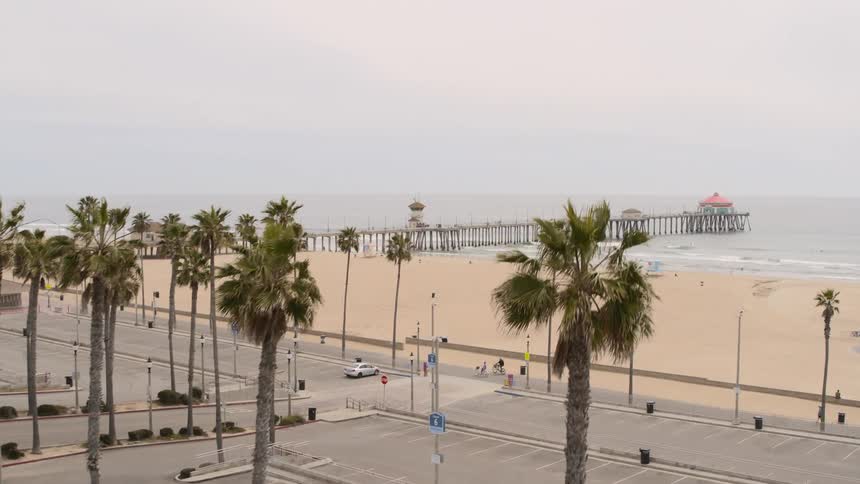 People ride bicycles and walkalong a path next to the beach