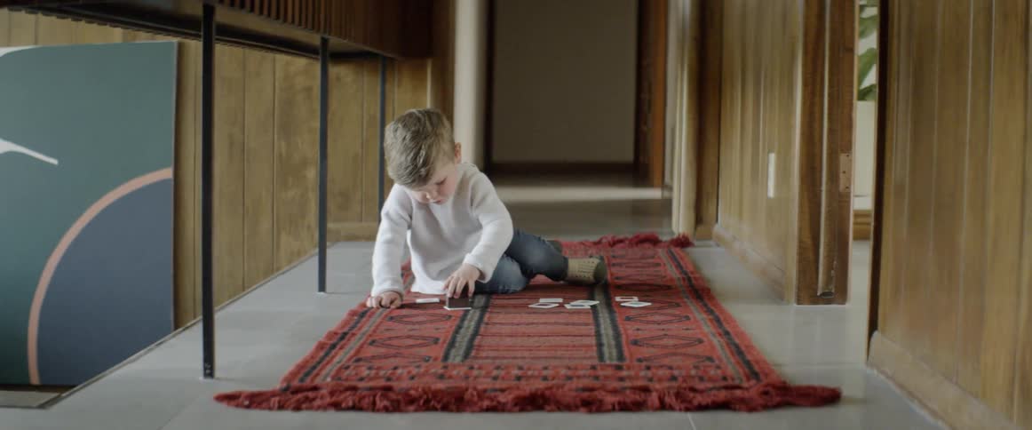 A little boy sits on the floor and plays